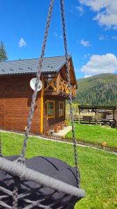a log cabin with a swing in front of it at Котедж "Смерековий затишок" in Vorokhta