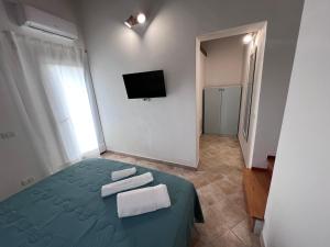 a bedroom with a green bed with towels on it at RossoScirì in Calatafimi