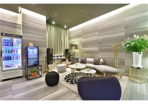 a living room with a couch and tables and a tv at 엠플레이스호텔 in Incheon