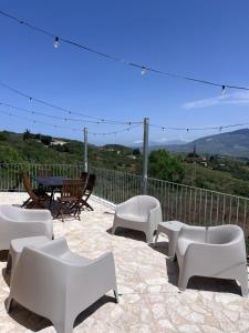 a patio with white furniture and a table and chairs at RossoScirì in Calatafimi