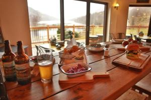 a wooden table with food and a sandwich and beer at MacDonald Hotel & Cabins in Kinlochleven