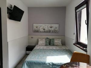 a small bedroom with a bed and a television at ВЛАД ДОМ Студио in Vratsa