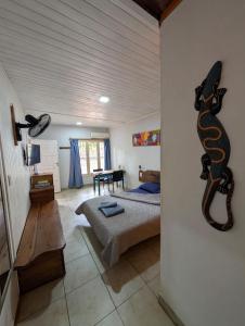 a room with a bed and a snake on the wall at Aloha hospedaje in Puerto Iguazú +13 photos