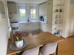 a kitchen with a wooden table with a vase of flowers on it at Landhuis Sint Nyk in Sint Nicolaasga