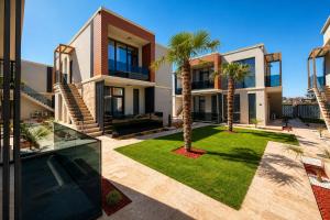 an image of a house with palm trees in the yard at Office Villas Costinesti in Costinesti