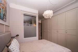 a bedroom with white cabinets and a chandelier at Villa Botanica in Neustadt an der Weinstraße