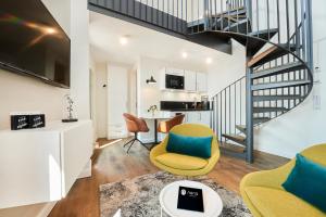 a living room with a staircase and a yellow chair at Nena Apartments Bremen by LESA in Bremen