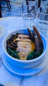 a bowl of fish and vegetables on a table at Casa Pichay Family Room in Vigan