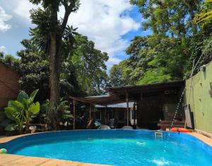 a swimming pool in front of a house at Aloha hospedaje in Puerto Iguazú