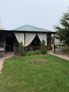 a house with a gazebo in a yard at Rest House in Cholpon-Ata