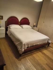 a bedroom with a large bed with a red headboard at Casa Daniela in Velletri