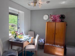 a dining room with a table and a clock on the wall at Waldblick-Appartement in Baiersbronn +28 photos