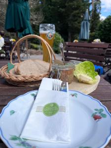 a table with a plate of food and a glass of beer at Waldblick-Appartement in Baiersbronn