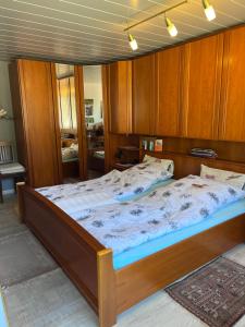 a large bed in a room with wooden cabinets at Waldblick-Appartement in Baiersbronn