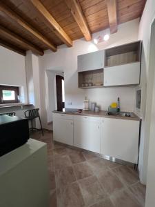 a kitchen with white walls and wooden ceilings at RossoScirì in Calatafimi
