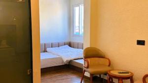 a small bedroom with a small bed and a chair at Yes Hotel By The Ganges Rishikesh in Rishīkesh