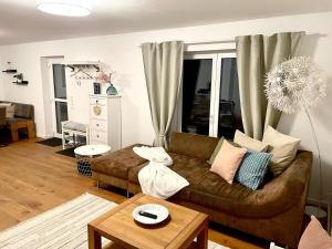 a living room with a brown couch and a table at Gemütliche Ferienwohnung Casa Caliora, 8km zum Biggesee in Drolshagen