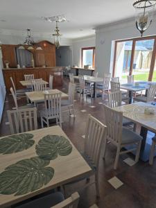 a dining room with tables and white chairs and a room with at Pensjonat Nad Rzeką in Wisła
