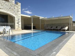 a swimming pool in the middle of a house at Villa Ovgoro - Luxury 3-Level Villa with Heated Pool, Jacuzzi and Panoramic Views in Kamilari