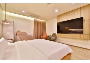a hotel room with a bed and a flat screen tv at 엠플레이스호텔 in Incheon