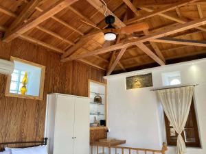 a bedroom with a ceiling fan in a room with wooden walls at Melinda Tower in Plomari