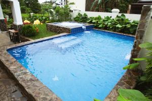 a swimming pool with blue water in a yard at Balay Pahuwai Bed & Breakfast in Tagaytay