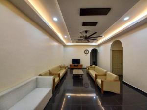 a waiting room with couches and a ceiling fan at mulia homestay in Teluk Intan