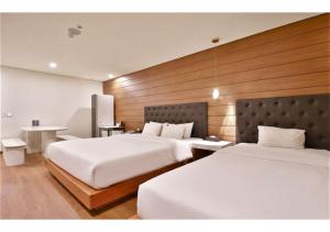 a hotel room with two beds and a table at 엠플레이스호텔 in Incheon