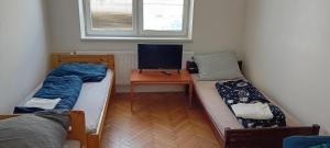 a room with two beds and a desk with a computer at Vilem in Komárov