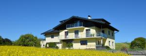 a large yellow house with a black roof at Haus Gruber in Attersee am Attersee