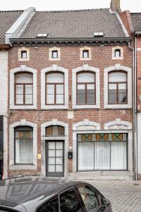 a brick building with a car parked in front of it at Vakantiewoning Gast in Borgloon