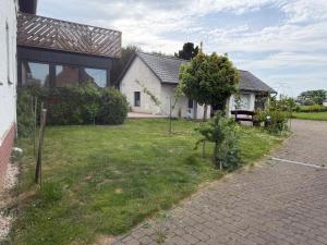 a white house with a grass yard and a building at Burato`s Haus in Minden