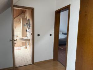 a bathroom with a sink and a door leading to a bedroom at Burato`s Haus in Minden