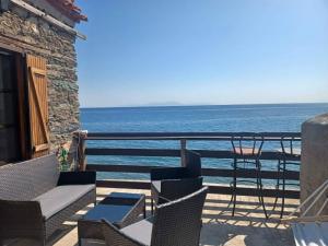 a balcony with chairs and a view of the ocean at Melinda Tower in Plomari