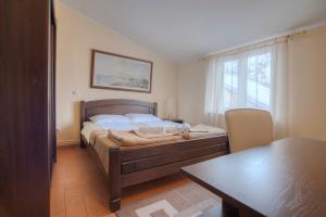 a bedroom with a bed and a table and a dining room at Pansion 22 CETINJE in Cetinje