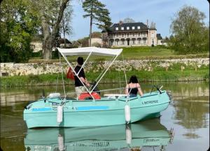 a man and a woman in a blue boat on the water at Paris Giverny familles & professionnels in Freneuse