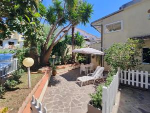 a patio with a table and an umbrella next to a house at La casa di Iole in Maratea