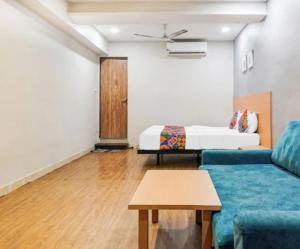 a living room with a couch and a bed at Hotel Bluesky in Surat