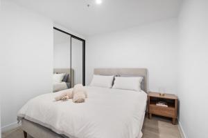 a bedroom with a white bed with towels on it at Premium 2BR Braddon, Marriott Amenities in Braddon +8 photos