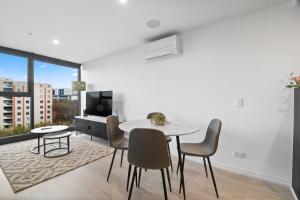 a dining room with a white table and chairs at Premium 2BR Braddon, Marriott Amenities in Braddon