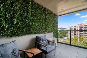 a green wall with two chairs on a balcony at Premium 2BR Braddon, Marriott Amenities in Braddon