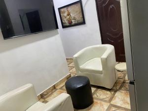 a waiting room with a chair and a stool at Beulah House Lounge in Ibadan