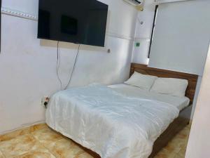 a bedroom with a bed with a flat screen tv on the wall at Beulah House Lounge in Ibadan