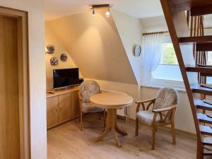 a room with a table and two chairs and a television at Haus *Üüs Aran* Wohnung Nr. 6 in Nebel