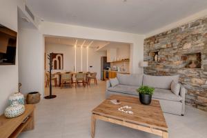 a living room with a couch and a table at Pnoe Villas Syros in Megas Gialos - Nites