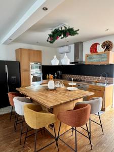 a kitchen with a large wooden table and chairs at Jasmin House in Cenon