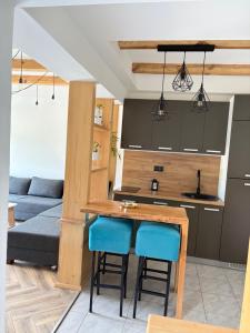 a kitchen with a table and some blue chairs at Luna Apartman in Višegrad