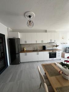 a kitchen with a table and a black refrigerator at InnPogradec Center in Pogradec
