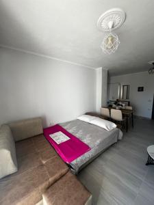 a bedroom with a bed with a pink blanket on it at InnPogradec Center in Pogradec