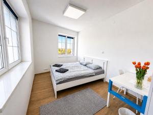 ein Schlafzimmer mit Bett, Tisch und Fenstern in der Unterkunft Biomade in Prag